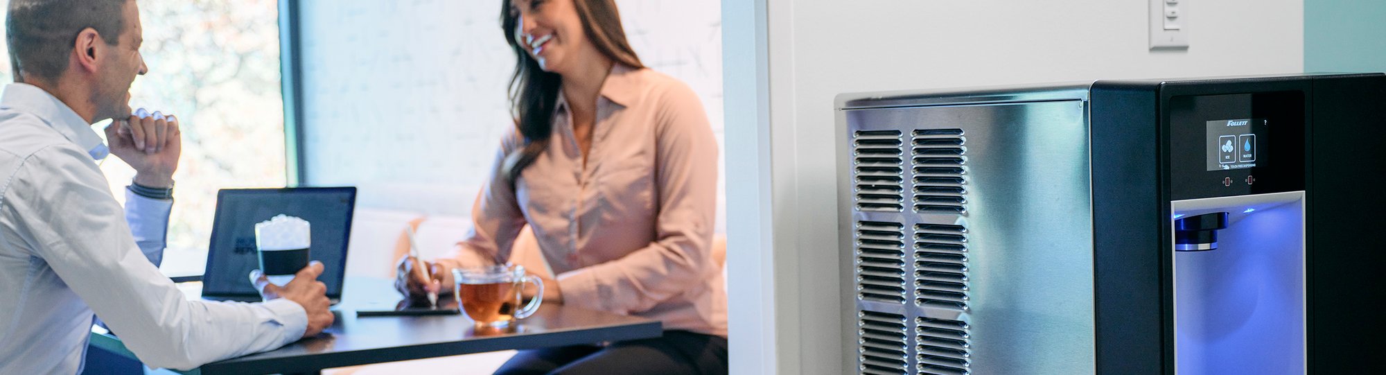 Champion dispenser in breakroom with talking coworkers