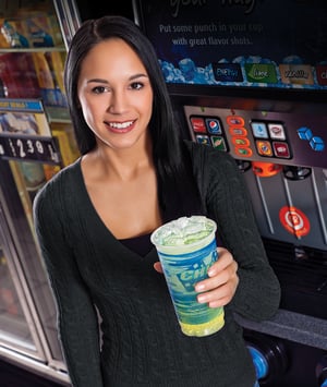 A woman in a convenience store holds a beverage with Chewblet ice