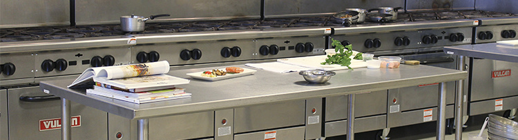 Restaurant kitchen close up of worktables and stoves